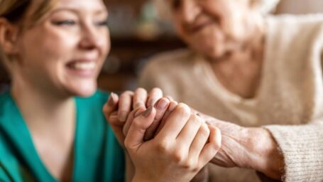 Cropped shot of a senior woman holding hands with a nurse